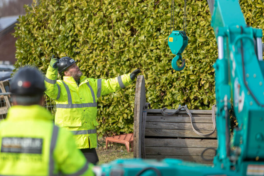 Slinger Signale Course image of crane operator and slinger singalling in high vis equipment